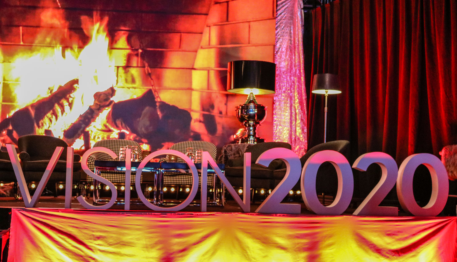 VISION 2020-bokstäver framför öppen spis i festlokalen med stämningsfull belysning
